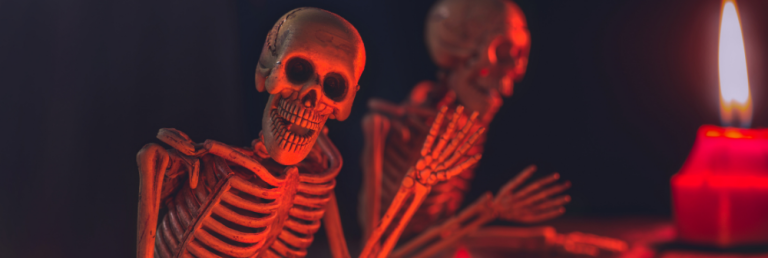 A lively skeleton raising a hand as red light flickers across its skull